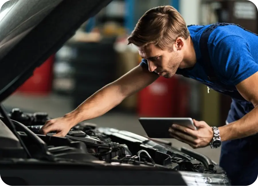 A mechanic using a workshop management software on a rugged tablet to manage repairs and inventory.
